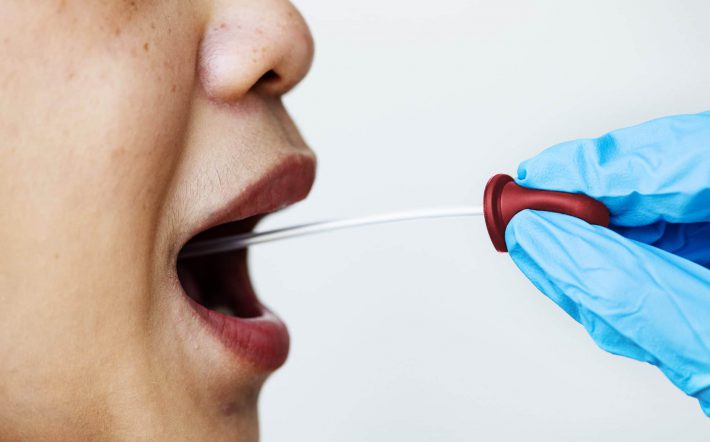 Woman getting a mouth swab to test for coronavirus
