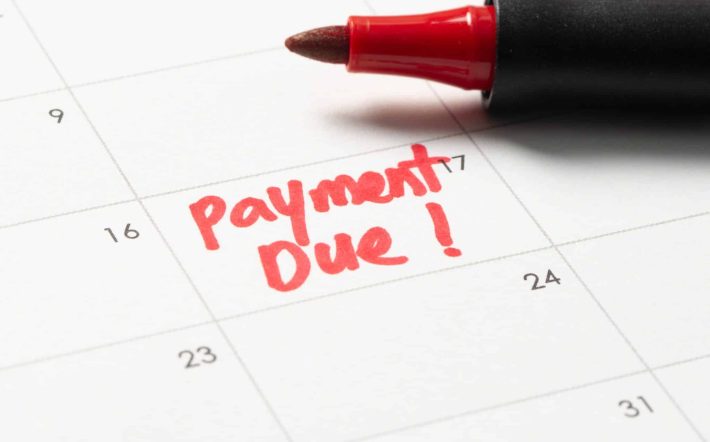 Calendar with the words payment due written in red ink with a marker pen, emphasizing a due date reminder. The image highlights the importance of payment deadlines.